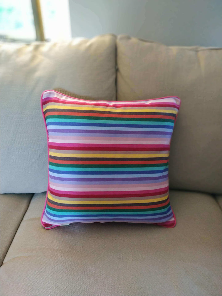 Rainbow cushion on a beige sofa close up