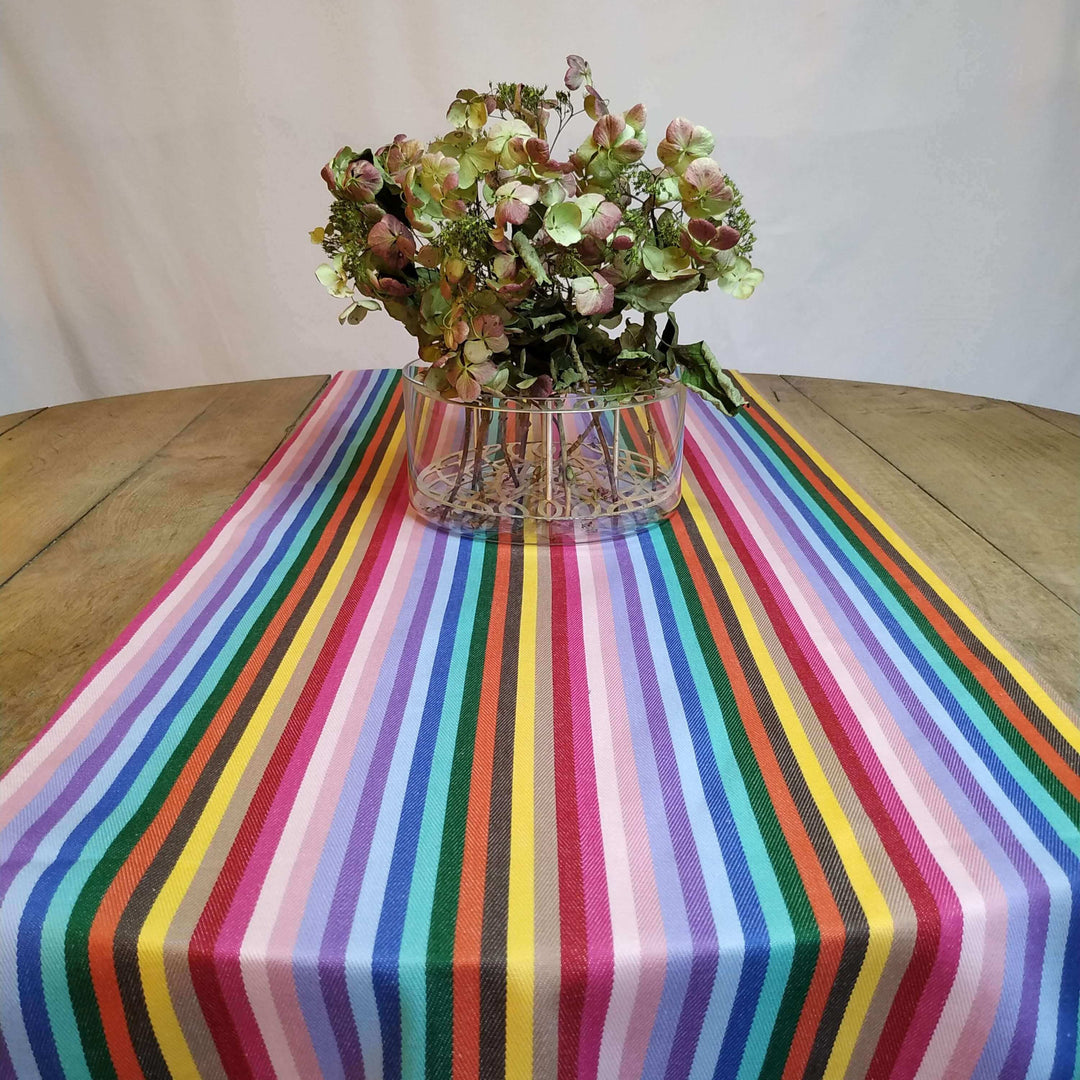 Table runner rainbow close up on a wooden table with flowers on it