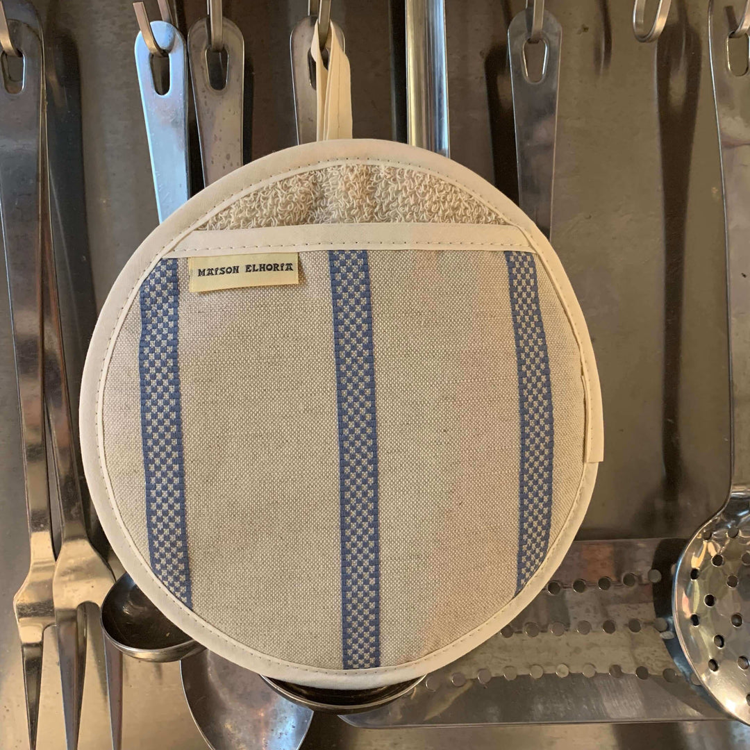 Pot holder round linen with blue stripes hanging with stainless steel kitchen cooking utensils 