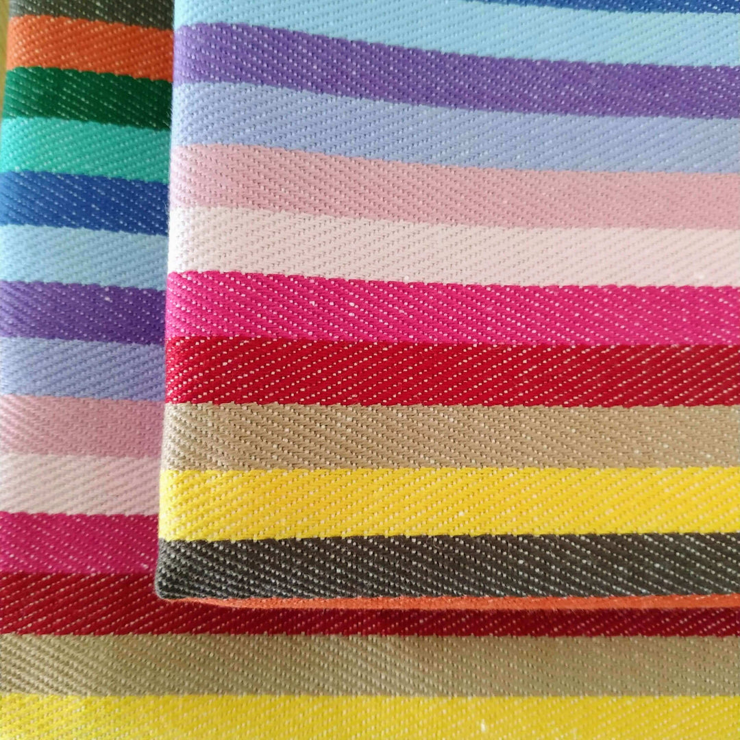 2 rainbow napkins, close up, folded above each other, overlapping enough to show the bottom one. 