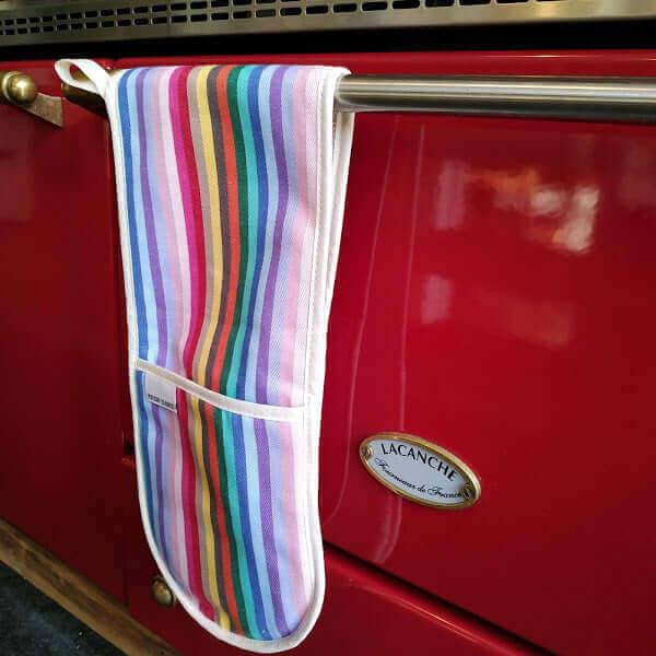 Premium rainbow organic cotton  double oven gloves hanging over the front of a Lacanche red cooker 