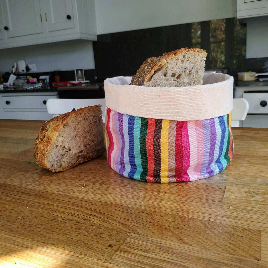 Bread basket rainbow on wooden table with bread on it and besides it