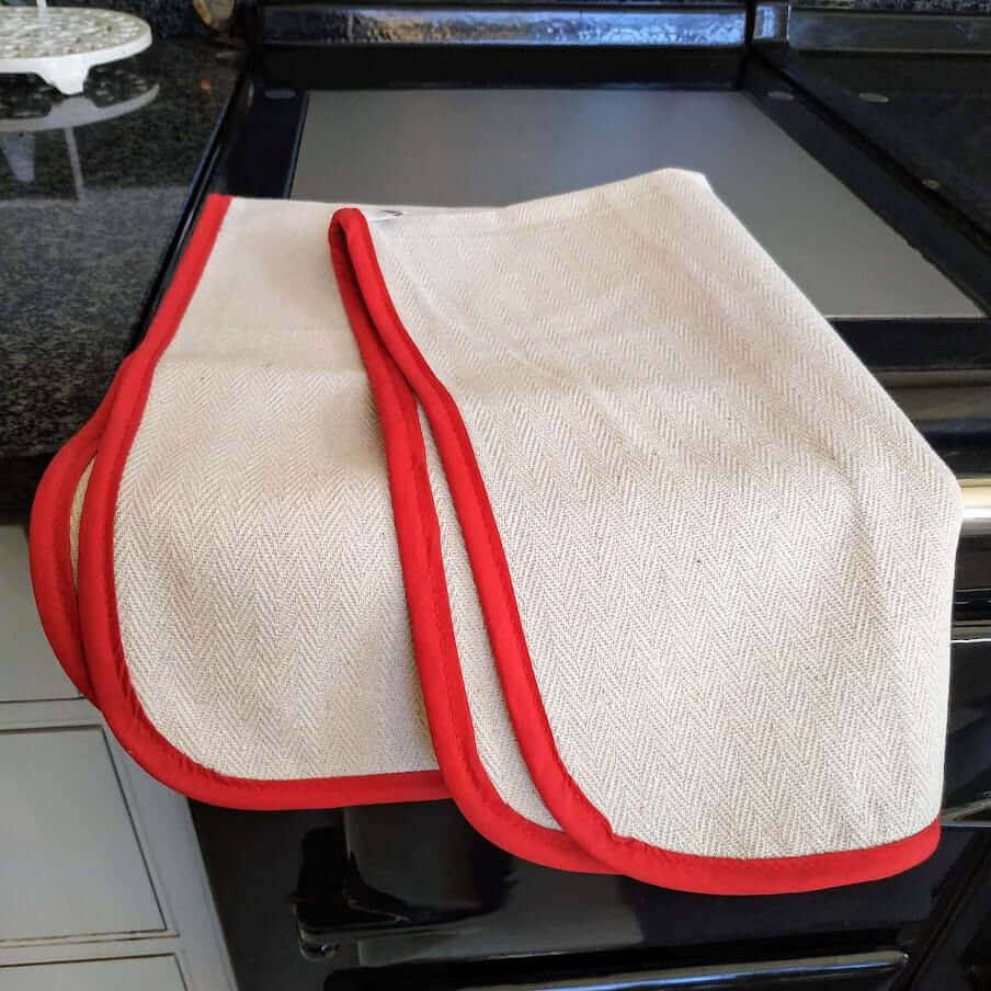 Oven cloth natural with red bias folded above an Aga plate warmer