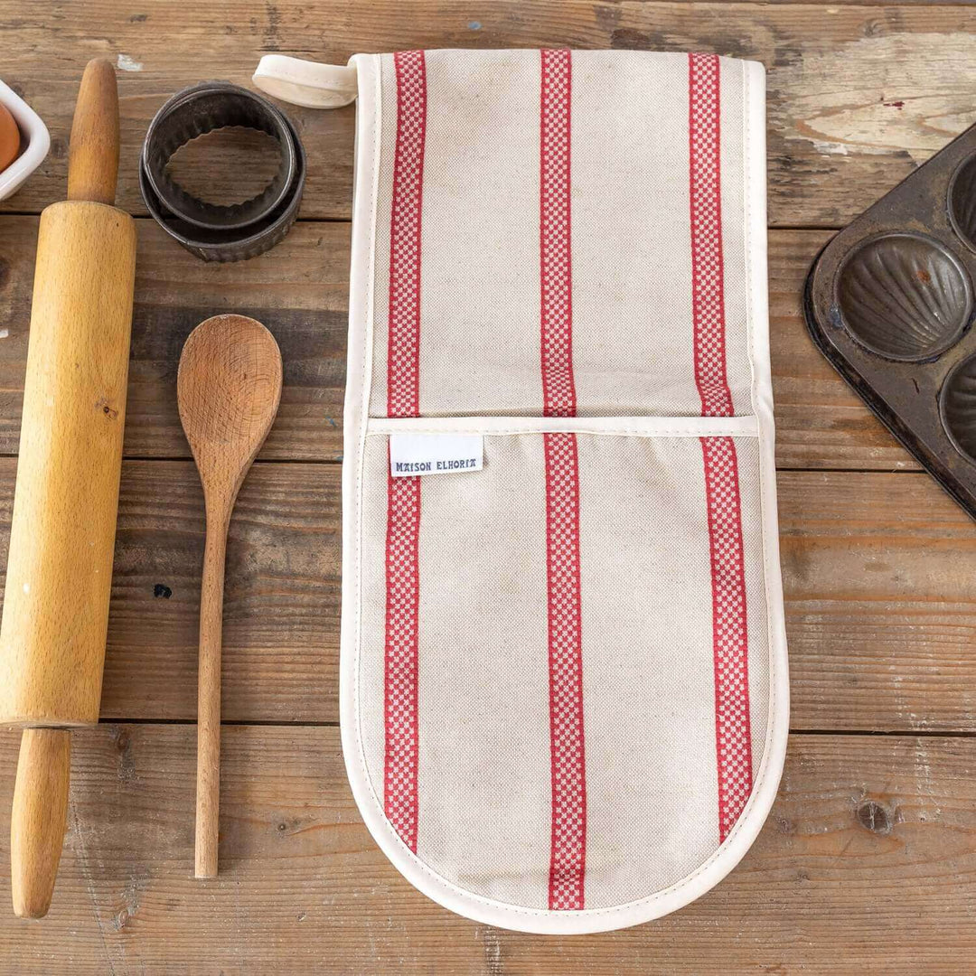 Premium linen union double oven gloves with red stripes on wooden table with baking accessories