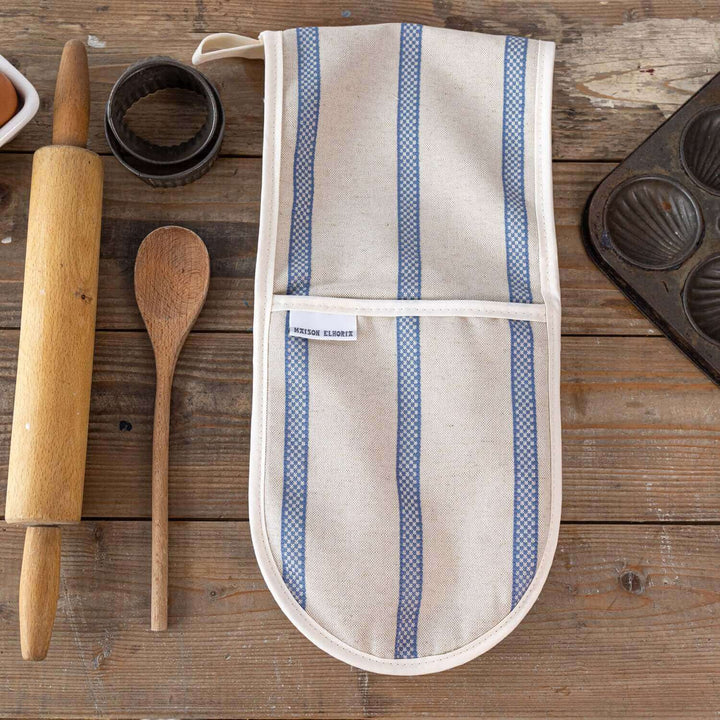 Premium linen union double oven gloves with blue stripes on wooden table with baking accessories