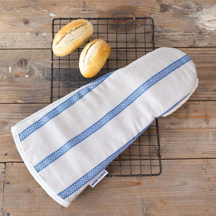 Linen union snapper gauntlet long oven glove with blue stripes on a wooden table with breads