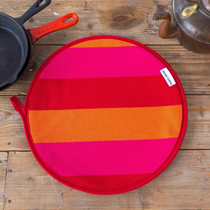 Red Orange pink striped premium quality insulating Aga hob plate cover on wooden surface with cast iron pans and antique kettle from maisonelhoria.com