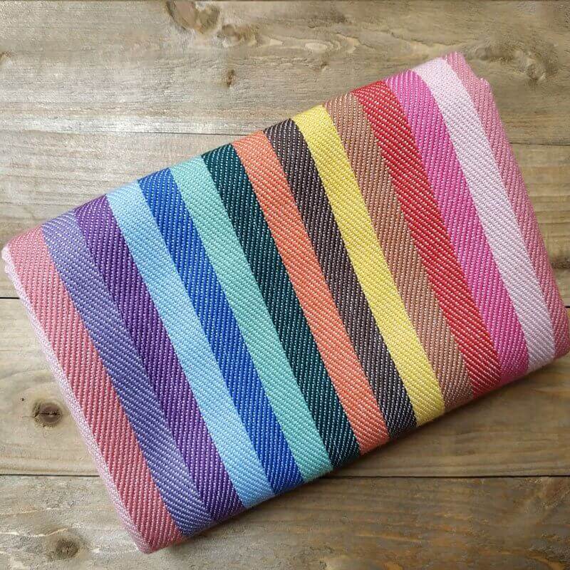 Folded rainbow kitchen towel on a wooden table